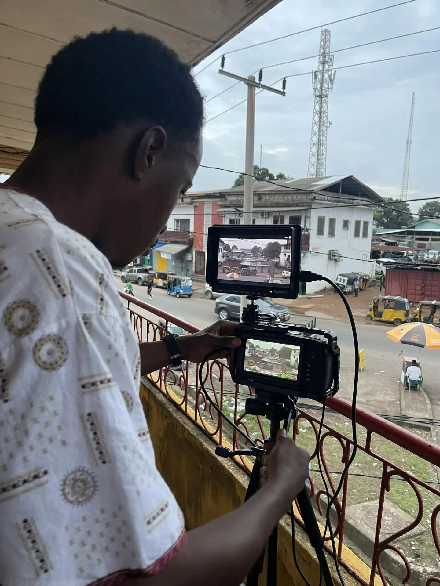 Filmmaker framing a street scene on a monitor and cinema camera